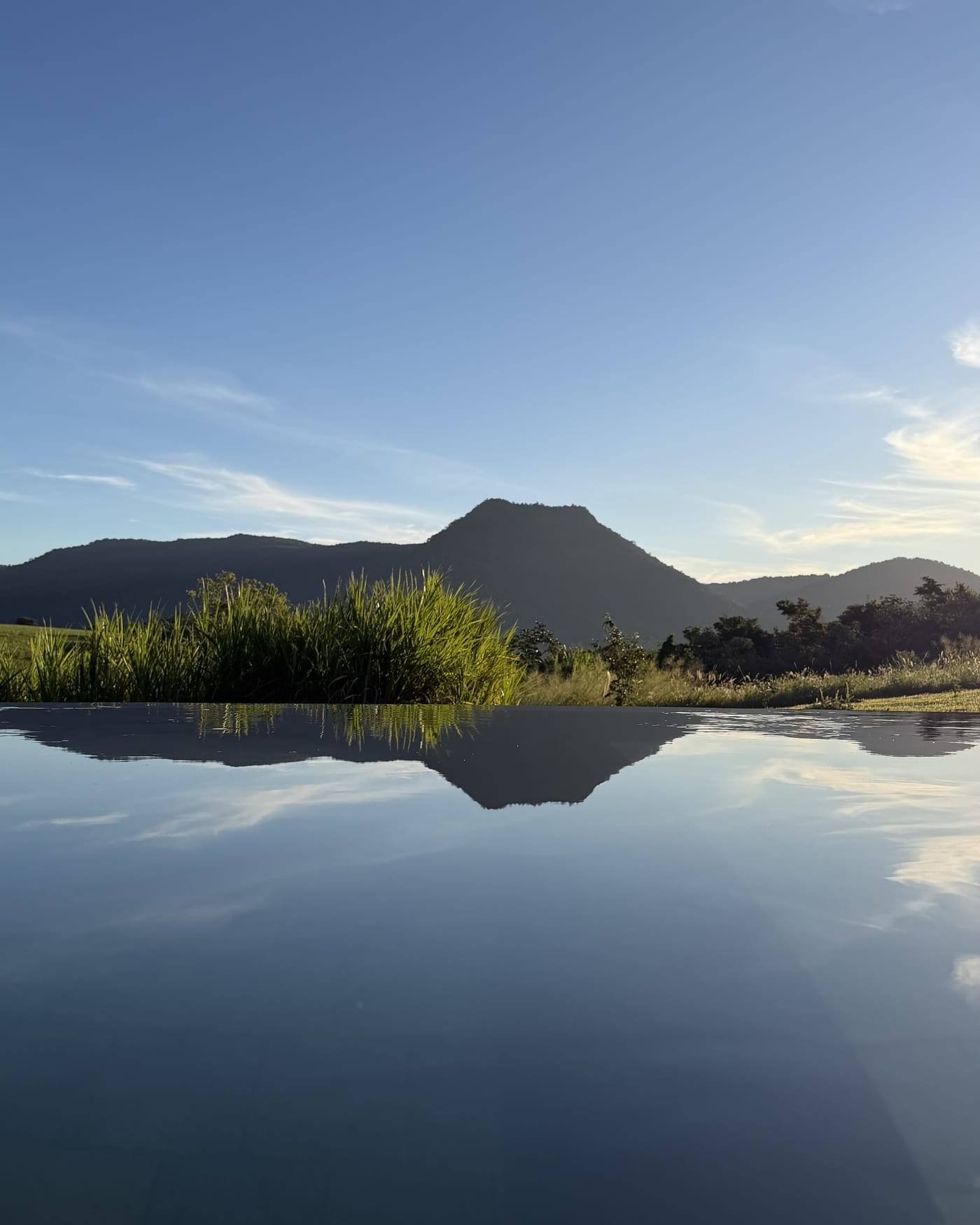 El agua quieta a la tarde, devolviendo el Cerro Amor entero como un espejo.